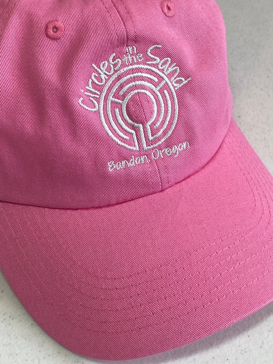 Bright pink cap with logo embroidered in silver thread.
